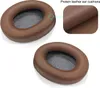 Two brown protein leather ear cushions for headphones are shown against a white background. A close-up inset shows the texture of the protein leather. Podgląd zdjęcia produktu