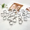 A collection of stainless steel cookie cutters arranged on a marble surface, with a blurred magazine in the background. Produktbild-Vorschau