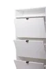 A close-up view of a white, three-door shoe cabinet with ribbed doors and black handles, against a white background. Produktbild-Vorschau