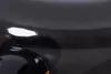 A close-up view of a black object with reflective surfaces, showing some text and a bright highlight. Voir les images du produit