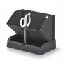 A dark gray planter with white scissors inside, set against a white background. Náhled obrázku produktu