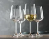Four wine glasses are arranged on a surface, with one glass filled with white wine. Náhled obrázku produktu