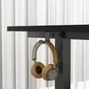 A pair of headphones hanging from a desk hook. Podgląd zdjęcia produktu