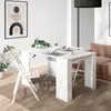 A white dining table set for a meal in a modern dining room with a sofa and artwork in the background. Produktbild-Vorschau