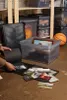 A person is sorting through photos next to storage bins and a basketball. Produktbild-Vorschau