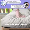 A hand pressing into a thick, light gray cushion, with marketing text overlays and inset images of filling and ties. Náhľad obrázku produktu