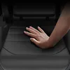 A hand is shown pressing down on the seat of a black gaming chair, highlighting its cushioning. Produktbild-Vorschau