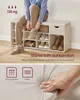 A person is sitting on a shoe bench and tying their shoes. The bench has multiple compartments for shoes and a drawer. Produktbild-Vorschau