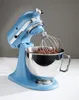 A light blue stand mixer with a whisk attachment mixing chocolate batter in a silver bowl. Podgląd zdjęcia produktu