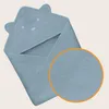 A blue hooded towel for babies, folded and displayed against a light beige background. A magnified circular inset shows the texture of the fabric. Náhled obrázku produktu