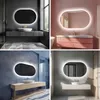 Collage of four different bathroom vanity setups, each featuring an illuminated oval mirror. Produktbild-Vorschau