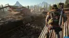 A man stands on a rooftop overlooking a scene of destruction with derailed trains and a large building in the background. Produktbild-Vorschau