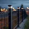A fence with solar-powered post lights at dusk. Voir les images du produit