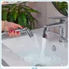 A hand holding a bidet sprayer over a sink with water running from a faucet. Anteprima dell’immagine prodotto