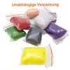 Several small bags of colorful material, likely craft supplies, are arranged in a pile. Produktbild-Vorschau
