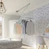A bedroom with a ceiling-mounted clothes drying rack with clothes hanging on it. Podgląd zdjęcia produktu