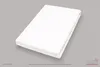 A white fitted sheet is folded and placed on a gray surface. Produktbild-Vorschau