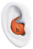 A close-up view of an orange earbud with a black 'b' logo, placed inside a white ear mold. Anteprima dell’immagine prodotto