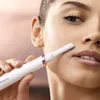 A close-up shot of a woman using a Philips facial trimmer. Náhled obrázku produktu