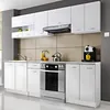 A modern, white kitchen setup featuring cabinets, a stove, sink, and coffee maker. Náhled obrázku produktu