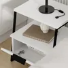A close-up shot of a white nightstand with black legs, showing its shelves and a drawer. Produktbild-Vorschau