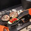 A close-up shot of sausages and vegetables being cooked on a grill. Produktbild-Vorschau