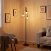 A living room scene with a floor lamp, armchair, and sofa. Produktbild-Vorschau