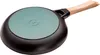 The underside of a black frying pan with a light brown wooden handle and a light green circular insert on the bottom. Text is visible on the green insert. Náhľad obrázku produktu