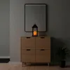 A lantern with an LED candle sits on top of a wooden cabinet, with a mirror above it and a plant to the side. Produktbild-Vorschau