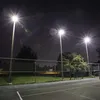 A night view of a tennis court with stadium lights illuminating the area. Anteprima dell’immagine prodotto