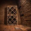 A wooden wine rack filled with wine bottles in a dark, brick-lined cellar. Voir les images du produit