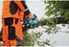 A person in protective gear is using a chainsaw to cut a tree branch. Náhled obrázku produktu
