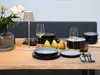 A table setting with plates, glasses, pears, and a lamp. Náhľad obrázku produktu