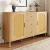 A modern wooden sideboard with rattan doors and drawers, displayed in a well-lit room with a lamp and flowers. Voir les images du produit