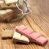 Several pieces of chocolate-like treats are arranged on a wooden surface, with more in a glass jar in the background. Produktbild-Vorschau