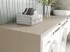 A modern laundry room with a countertop, washing machine, and stacked towels. Voir les images du produit