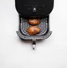 Two baked potatoes in an air fryer basket. Produktbild-Vorschau
