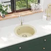 A kitchen sink and faucet on a countertop, with a window and cabinets visible. Anteprima dell’immagine prodotto