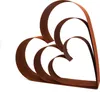 A sculpture of three nested hearts made of rusted metal, presented against a white background. Produktbild-Vorschau