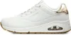 A side view of a white Skechers sneaker with gold accents. Voir les images du produit