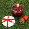A jar of strawberry jam with strawberries and a lid on grass. Anteprima dell’immagine prodotto
