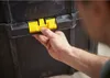 A person's hand is shown operating a yellow latch on a black toolbox. Voir les images du produit