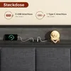 A shelf on a headboard with a phone charging, a USB hub, and a moon lamp. Produktbild-Vorschau