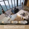 A modern living room with large windows overlooking a scenic view, where people are using cordless vacuum cleaners. Produktbild-Vorschau