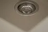 A close-up view of a sink drain with a metal strainer. Produktbild-Vorschau