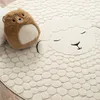 A close-up view of a round rug with a sheep design, featuring a plush toy. Produktbild-Vorschau