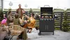 A group of people enjoying a barbecue outdoors with a gas grill. Podgląd zdjęcia produktu