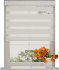 A white roller blind with horizontal stripes is shown in a window, with a vase of orange tulips on the windowsill. Produktbild-Vorschau