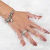 A woman's hand with jewelry on a white fluffy background. Náhled obrázku produktu