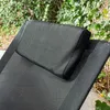 Close-up of a black recliner chair with a pillow, outdoors with greenery in the background. Anteprima dell’immagine prodotto